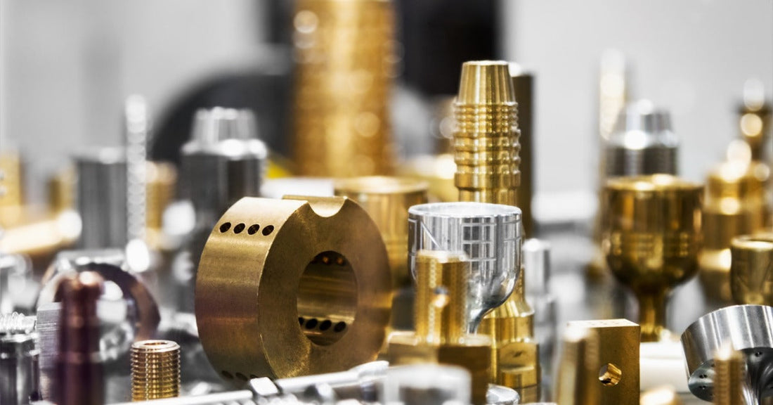 A table full of small, polished metal parts. The parts are arranged in various sizes, shapes, and colors.